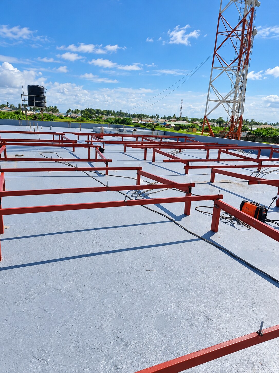 Frame installation in progress beside a telecom mast
